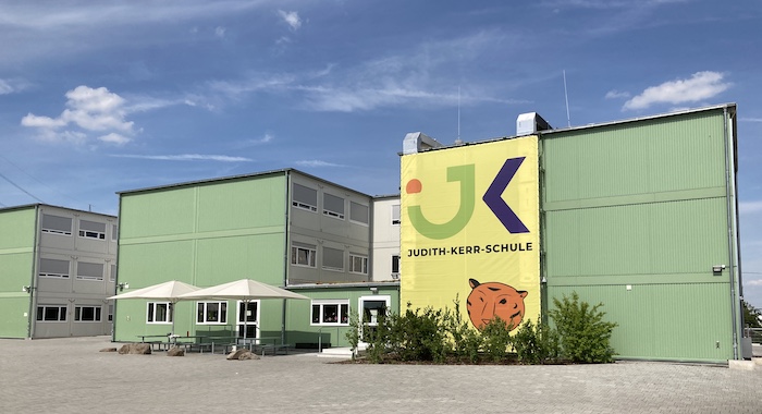 Das große Banner zeigt den neuen Namen der Schule.